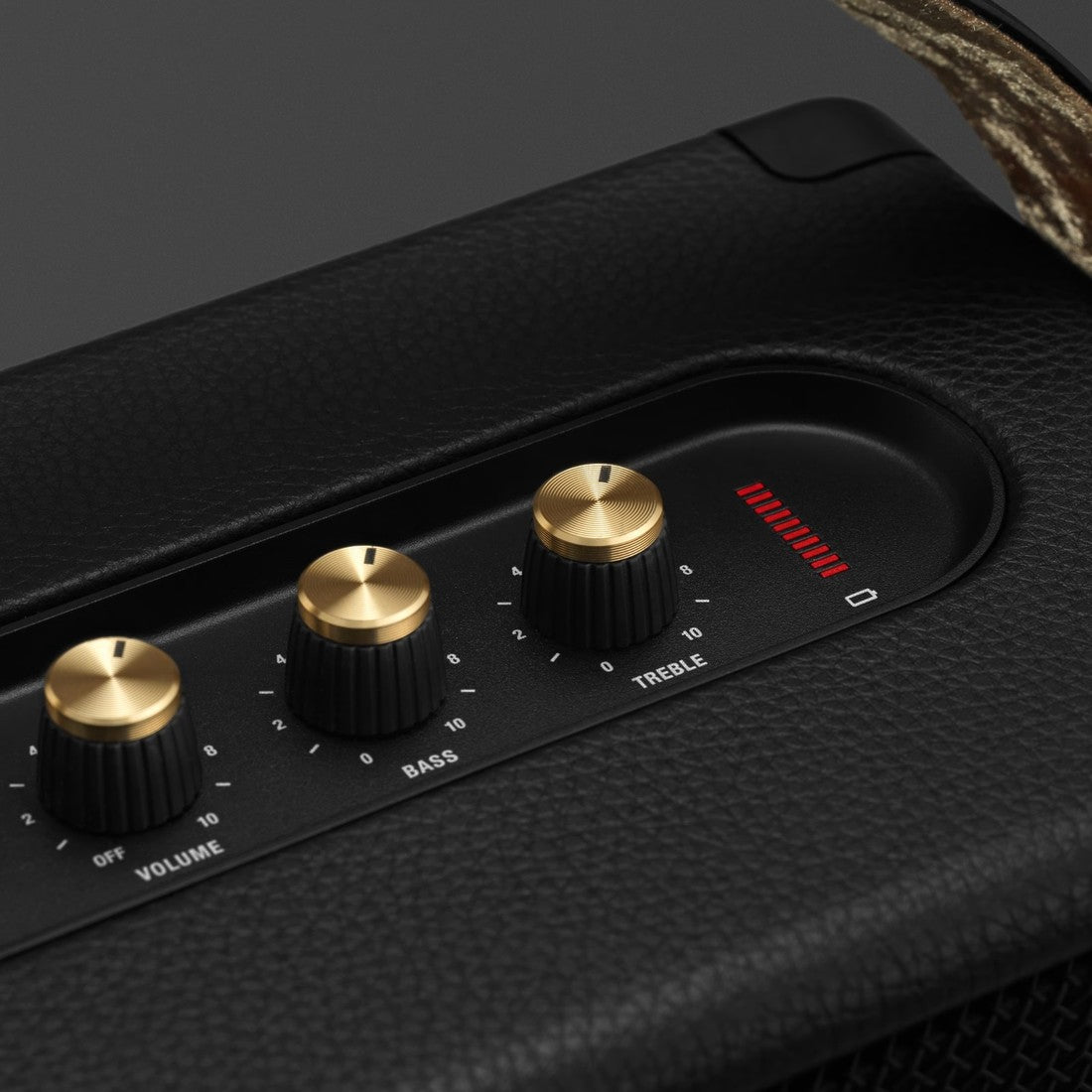 A close up of a Marshall KILBURN II BLACK AND BRASS speaker with gold knobs.
