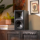 Klipsch The Sevens BK on modern media console beside plant and Americana art with warm lighting 2000x2000