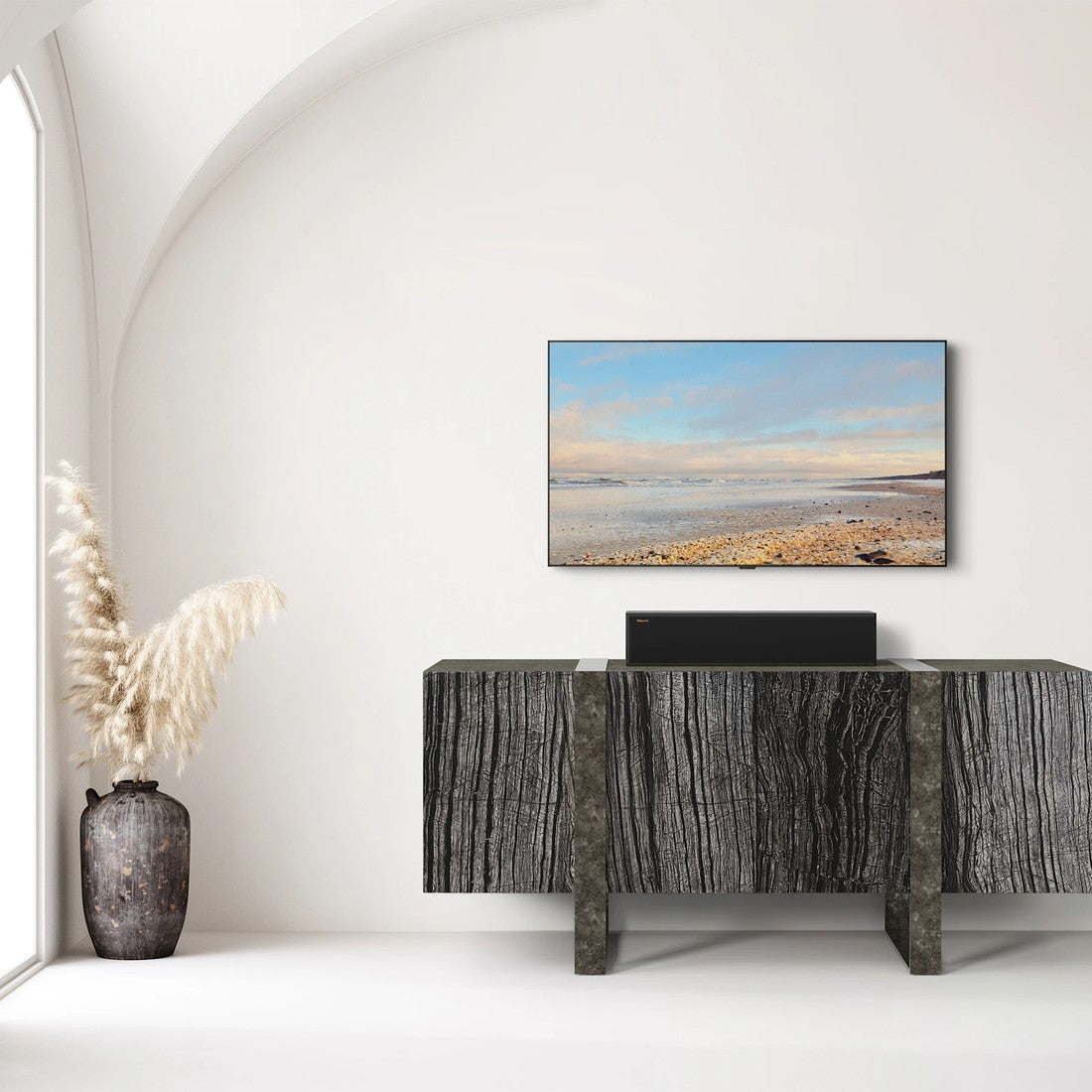 Modern interior with a television displaying a beach scene, a decorative vase, and a console table.