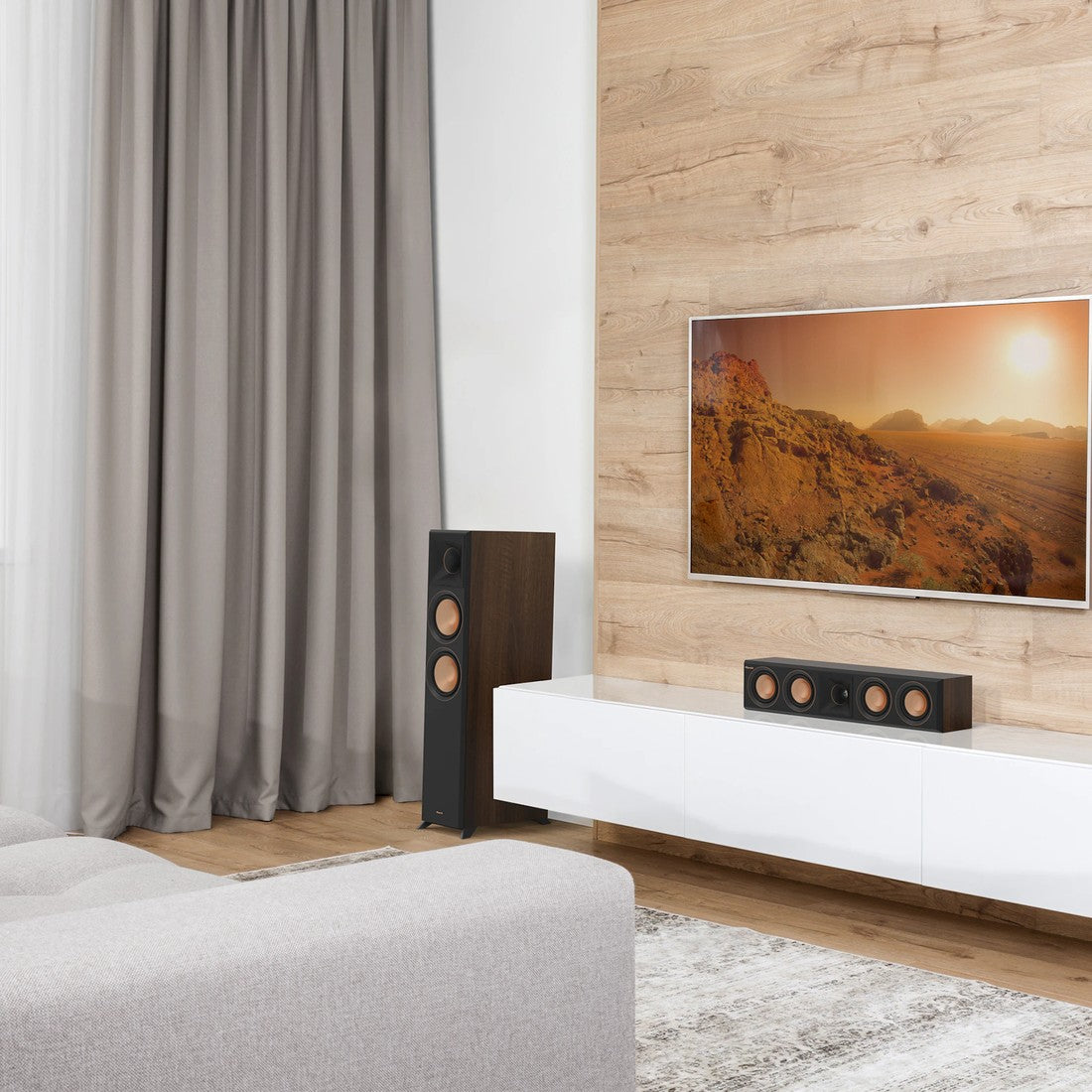 Modern living room with a TV, speakers, and a sofa.