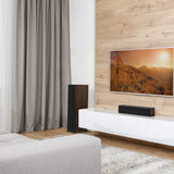 Modern living room with a TV displaying a nature scene, speakers, and a curtain.