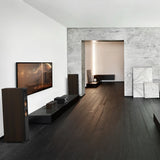 Modern living room with a television, speakers, and decorative elements.