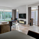 Modern living room with a television, speakers, and a sofa.