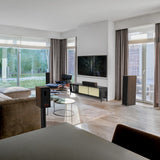 Modern living room with a television, speakers, and a sofa.